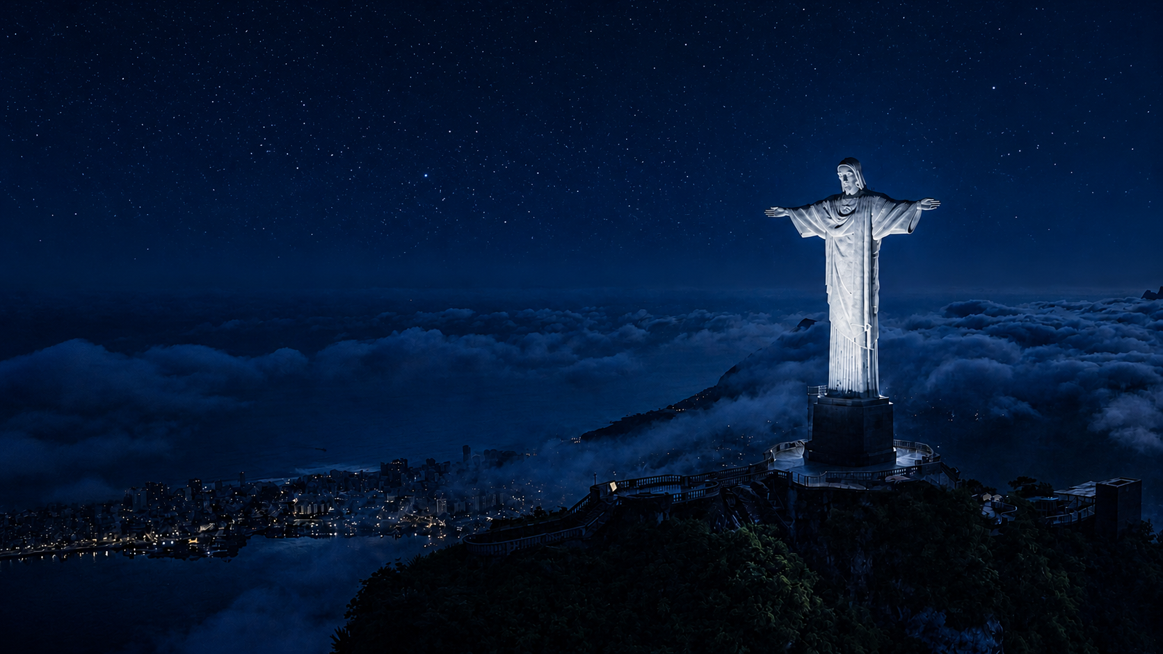 The illuminated Christ the Redeemer above Rio de Janeiro and a cloud layer under a starry blue night sky
